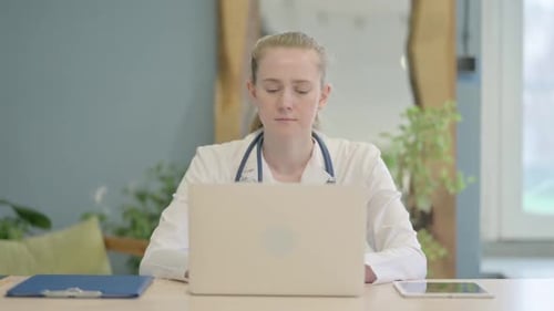 Smiling Doctor Working at Laptop in Modern Office