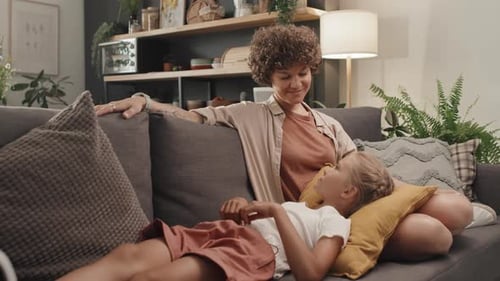 Woman and Child Relaxing Together on Couch at Home