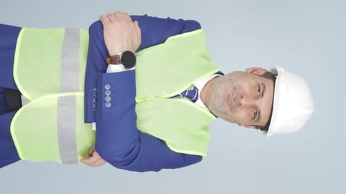 Vertical video of The engineer folds his arms and laughs at the camera.