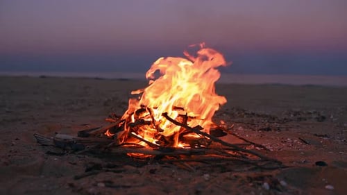 Lagerfeuer am Strand mit wunderschönem Sonnenuntergang oder Sonnenaufgang