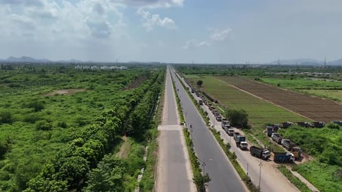 Aerial view of a highway running through lush green fields in Amaravathi, Vijayawada, India.
