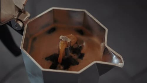 Hot creamy black coffee boiling in the vintage moka pot. Italian way of preparing coffee.