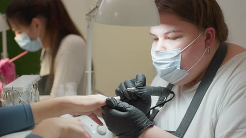 Woman Filing Nails in a Nail Salon