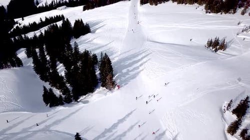 Luftbild des Skigebiets mit Leuten, die den Hügel hinunter snowboarden. Stock-Filmmaterial. Über den Ski fliegen