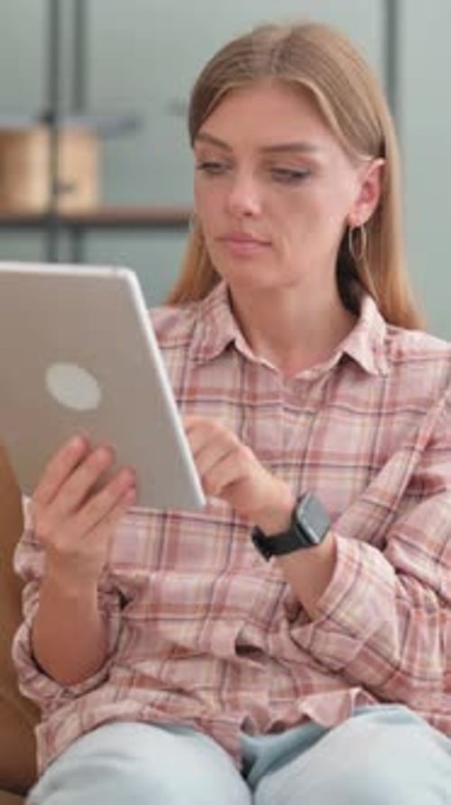 Woman Uses Tablet Device Sitting Indoors