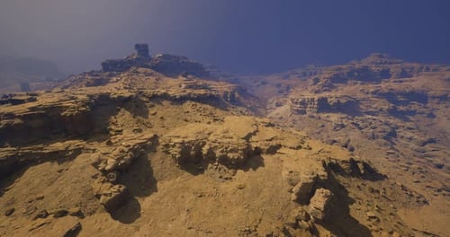 Paysage aride avec terrain rocheux et montagnes lointaines sous un ciel bleu