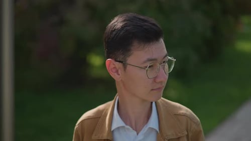 Casual Student Pauses Outdoors Student Gazing Sideways with Relaxed Campus Background Student in