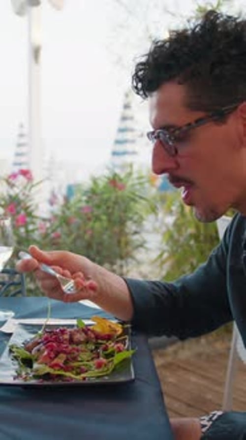 Man Admiring The Sea Landscape While Eating Lunch At The Beach Resort
