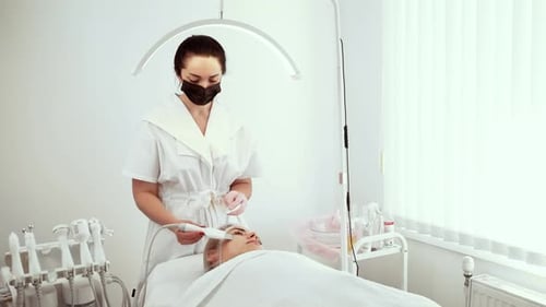 Cosmetologist Beautician Using Facial Skin Scrubber During Treatment at Skin Care Clinic Female