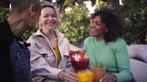 Smiling Women Enjoying Cocktails Outdoors