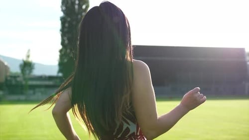 Smiling Woman Walks Happily Through Grassy Field
