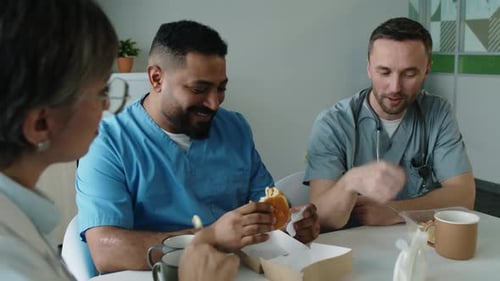 Hospital Employees Having Meal and Speaking in Break Room