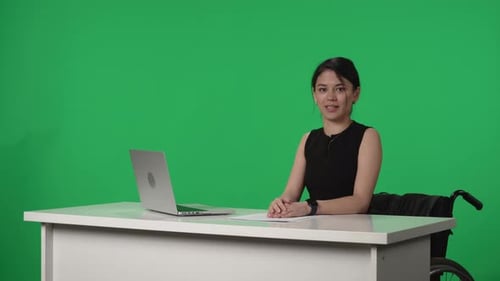 Programa de noticias de televisión en vivo Una presentadora asiática en silla de ruedas informa noticias en televisión contra la