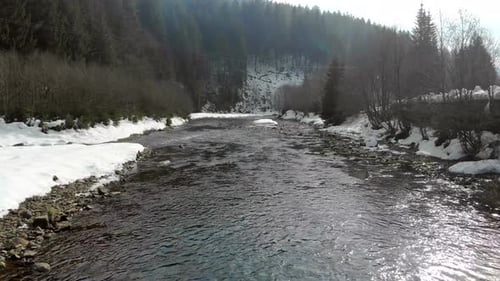 Tieffliegen über dem Fluss in den Winter Mountains