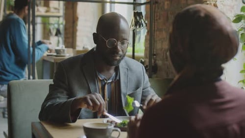 Black Man Having Lunch with Female Colleague in Cafe
