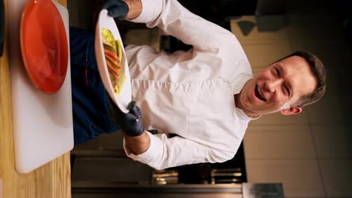Smiling Chef Displays Elegant Vegetable Dish in Kitchen