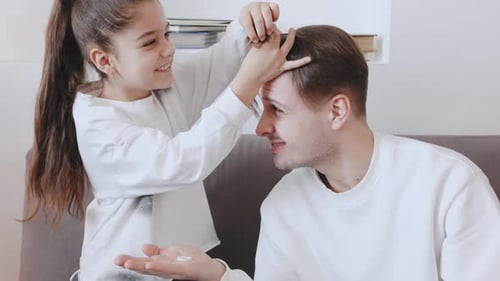 Playful Girl Puts Hair Ties in Father's Hair