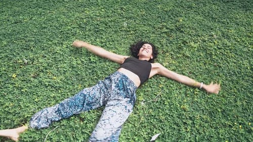 Attractive fit woman enjoys green grass with bursting energy, motion view