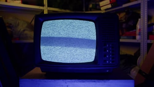 Vintage Television with Static on Screen in Dark Room