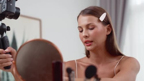 Woman Applies Lipstick in Mirror Filming a Video