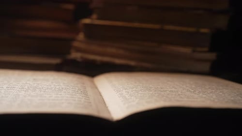 Open Book with Stack of Books in Background