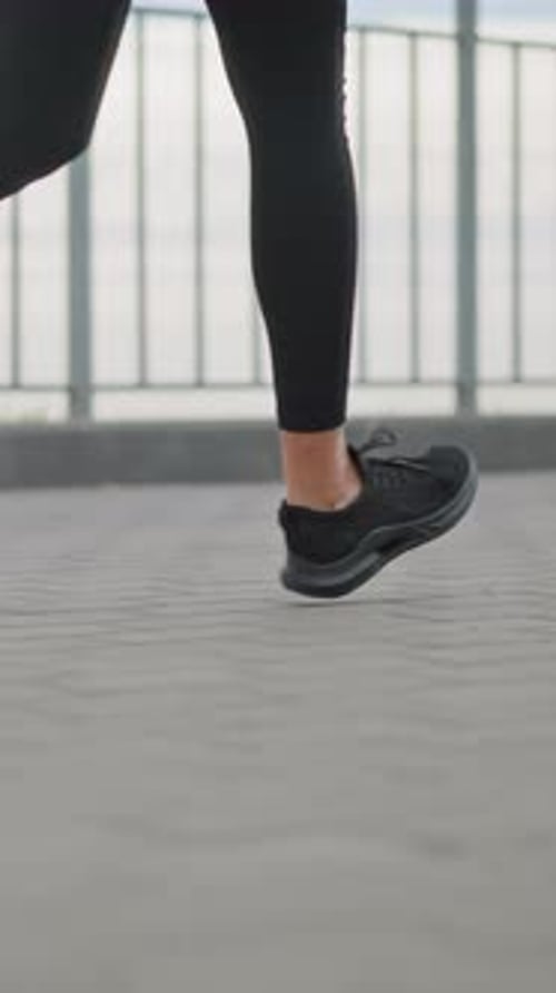Woman Jogging in Place Outdoors Wearing All Black