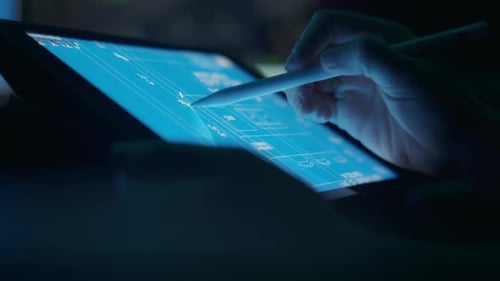 Hands Use Stylus on Tablet with Blueprint Design