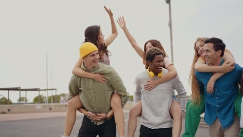 Friends Enjoy Piggyback Rides in Urban Setting