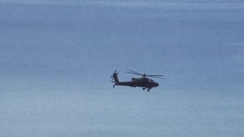 A Boeing AH-64 Apache Helicopter flying over Utah Lake