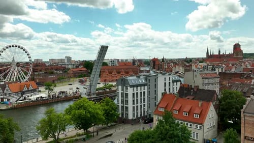 Aerial view of Gdańsk featuring the Motława River, a modern Ferris wheel, and historic buildings. Ci