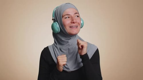Young Happy Woman in Headphones Listening Music and Dancing Disco Having Fun Relaxing on Party