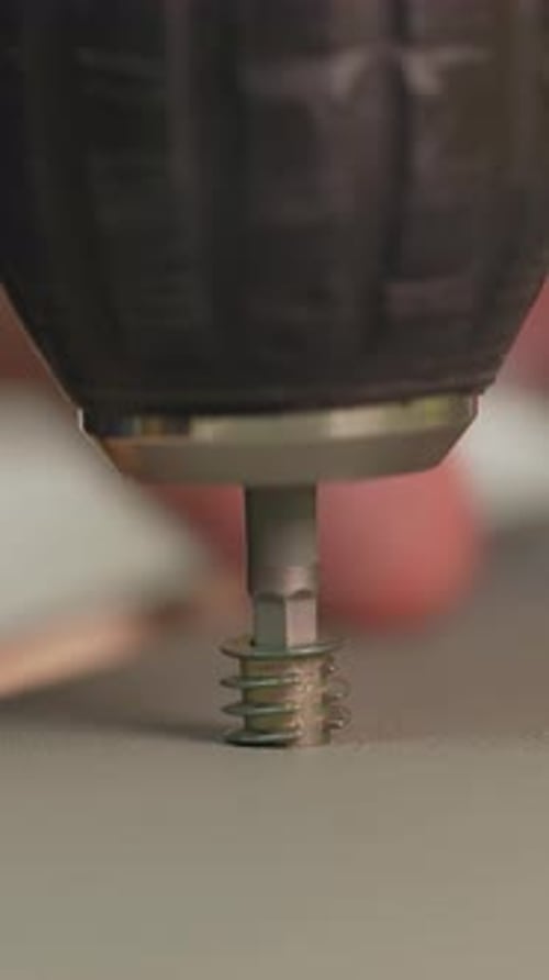 Close Up Driving Screw with Drill into Flat Surface