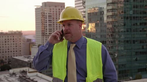Construction Manager on Rooftop Using Cell Phone Architect