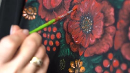 Close-up, female hands draw flowers on a dress