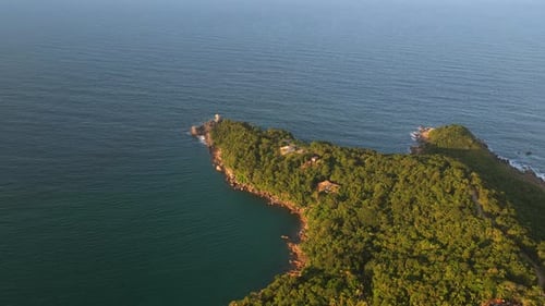 Luz do pôr do sol na península verdejante que se estende até as águas do Atlântico