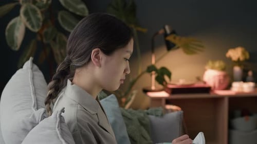 Young Woman Writing Notes and Using Laptop Working from Home