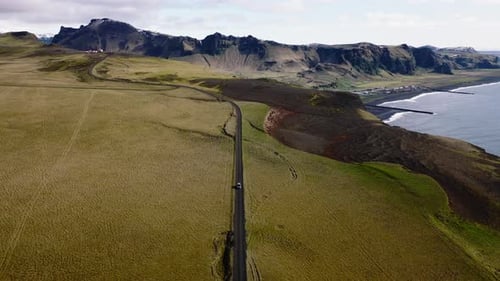Aerial View Of A Car On A Dirt Road And Coastal Landscape