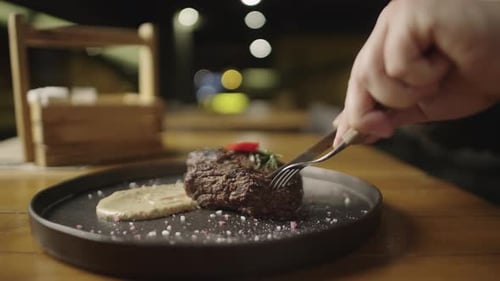 Slow Motion Video of Cutting a Piece of Steak with a Knife in a Restaurant