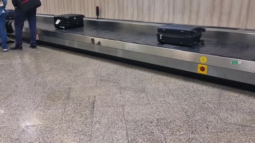 Shot of an airport baggage carousel with suitcases moving along the conveyor belt
