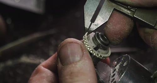 Close up of the hands of a goldsmith while he is working on a diamond ring. Concept: Style, fashio