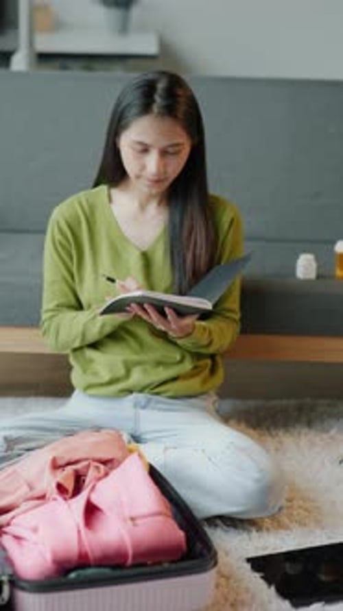 Woman Packs for Trip and Makes List