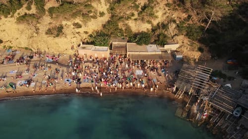 Aerial drone view of resort at Cala Benirras sea in Ibiza, Spain. crowded beach.