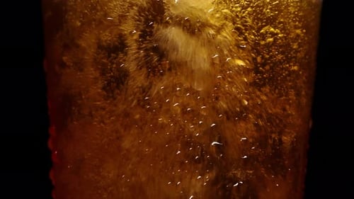 Close-Up of Golden Beer Pouring Into Glass with Bubbling Foam Texture