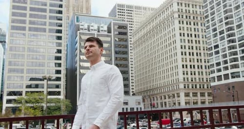 Man in white shirt poses in urban setting