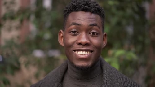 Young Man Smiling Confidently in Urban Environment