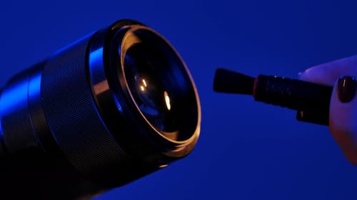 Cleaning Camera Lens with Brush Under Blue Neon Light
