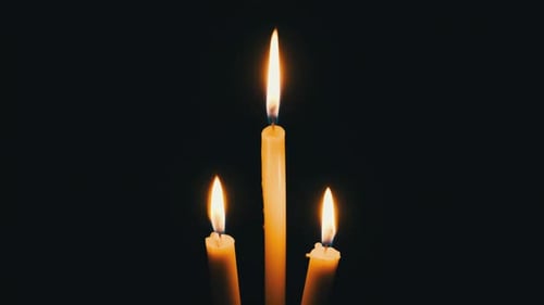 Three Candle Burns on a Black Background
