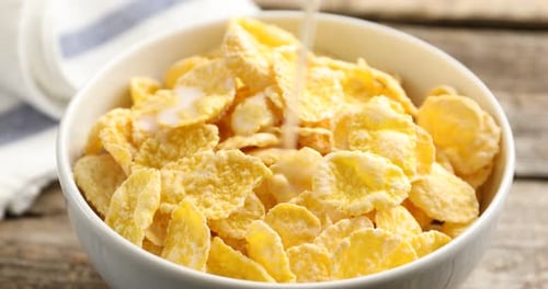 Pouring Milk onto Crunchy Cornflakes in Bowl