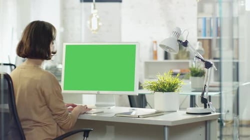 Creative Young Girl Works on Her Desktop Computer. Her Office/ Creative Studio is Brightly Lit. Com