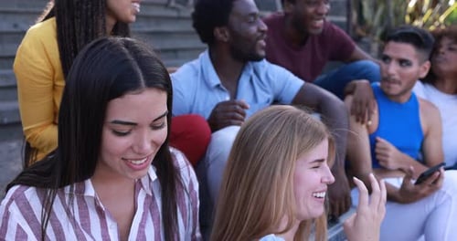 Diverse group of friends sit together laughing